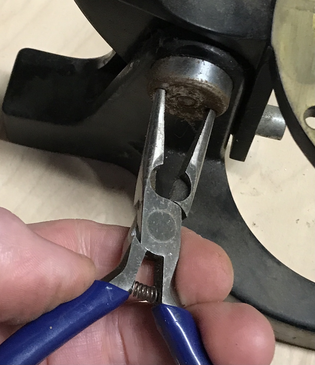 Needlenose pliers used to remove the nut